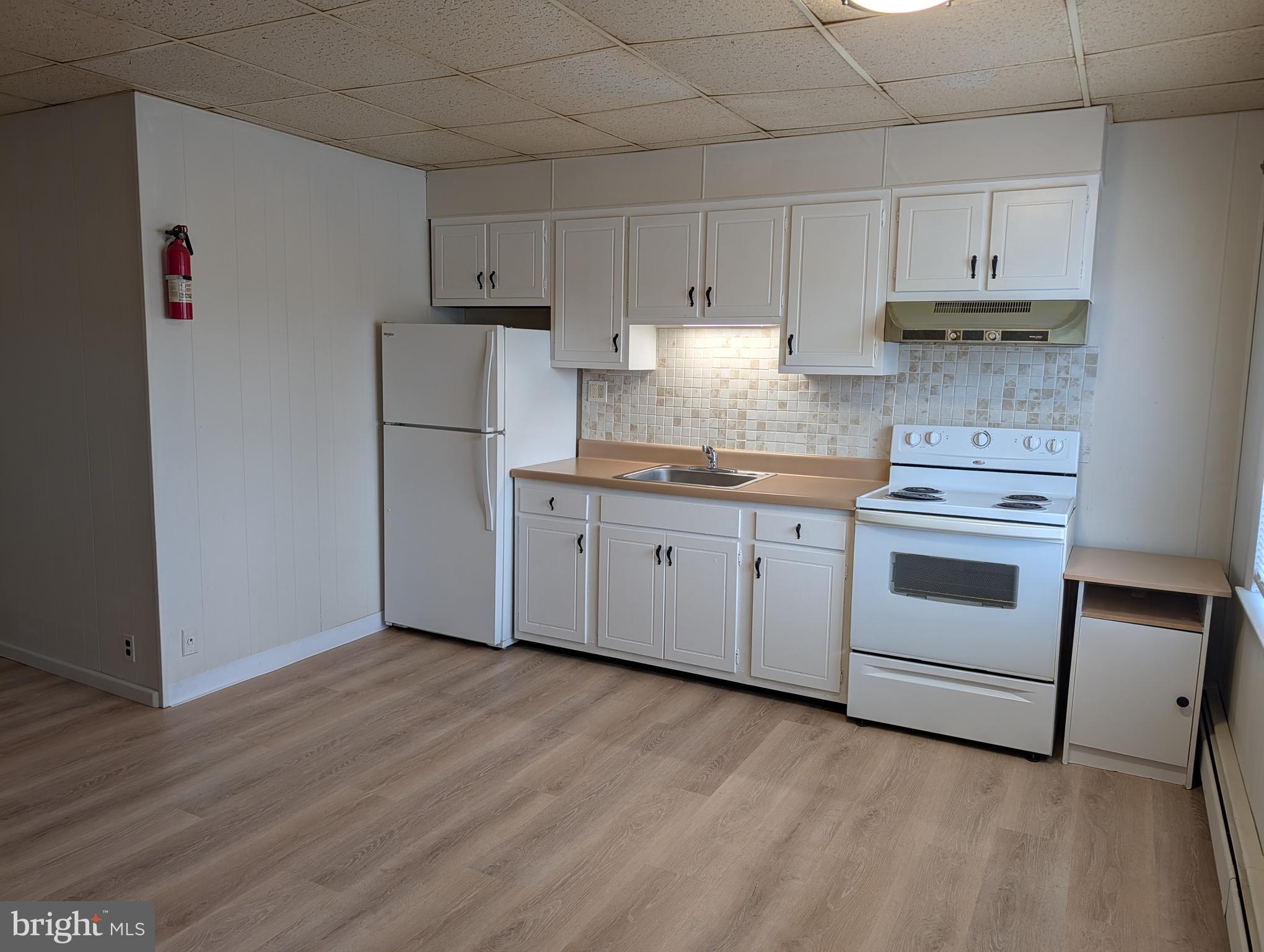 238 Main Street, Unit 3 Hellertown, PA 18055 - Photo 1 of 8 a kitchen with granite countertop white cabinets and white appliances