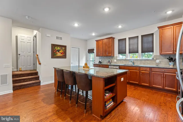 a kitchen with stainless steel appliances granite countertop sink stove and wooden floor