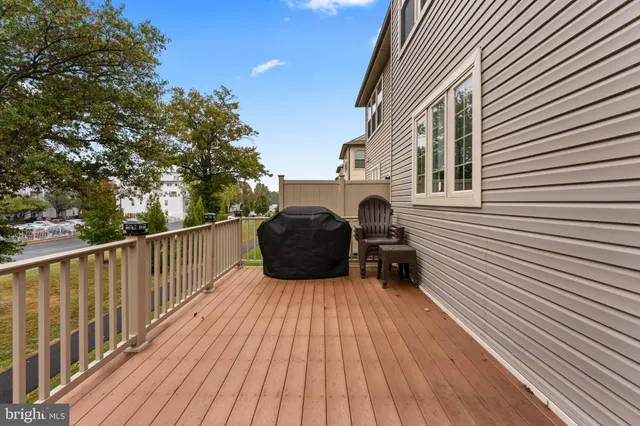 a view of a deck with wooden floor and fence with a trees