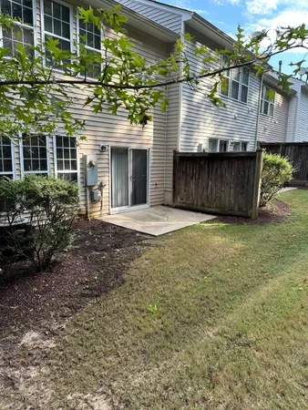 a view of a house with a yard and potted plants