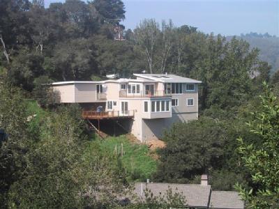 a aerial view of a house with yard and trees in the background