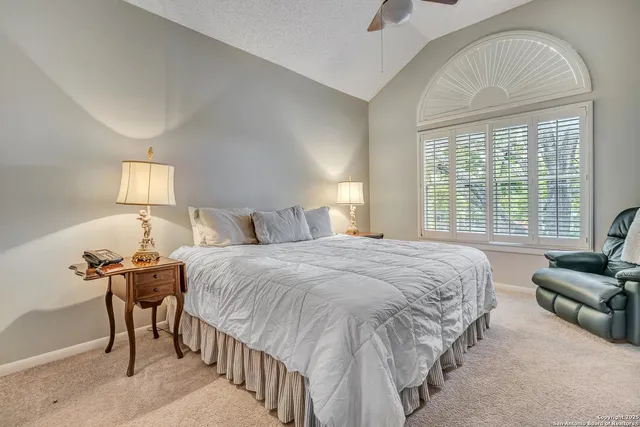 a spacious bedroom with a bed and a chandelier