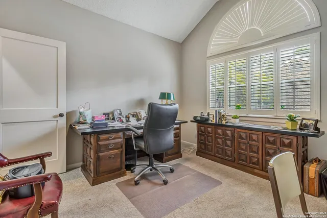 a view of a workspace with furniture and a window