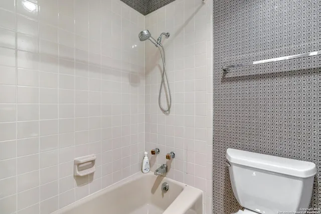 a bathroom with a toilet and shower