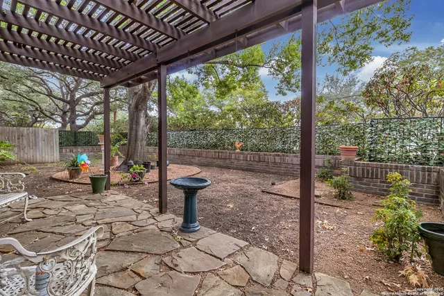 a view of a patio with table and chairs potted plants with wooden floor and fence