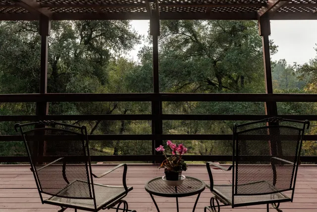 a view of a roof deck with table and chairs a barbeque with wooden fence