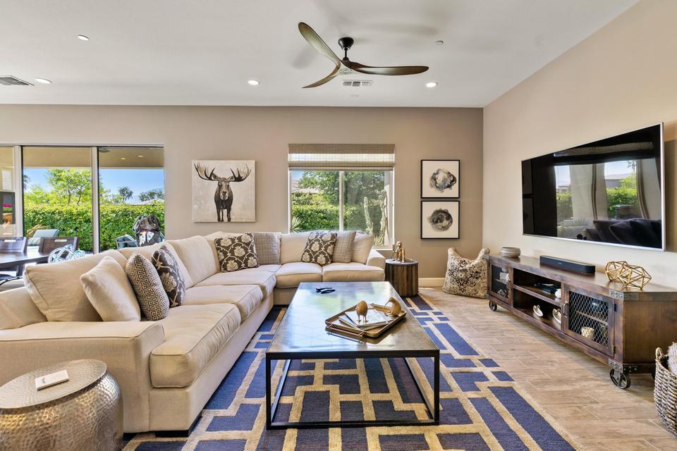 51790 South Two Palms Way Indio, CA 92201 - Photo 5 of 36 a living room with furniture a flat screen tv and a floor to ceiling window