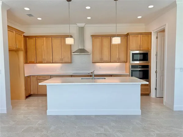 a kitchen with stainless steel appliances granite countertop a sink a stove and a refrigerator