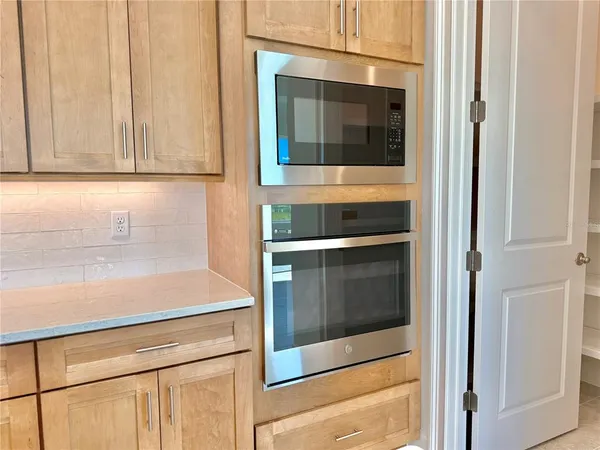 a kitchen with a sink a counter and chairs in it