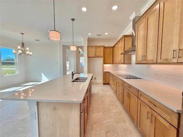a large white kitchen with a large counter top and stainless steel appliances