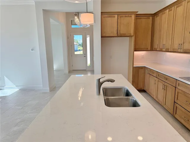 a large white kitchen with a large counter top and stainless steel appliances