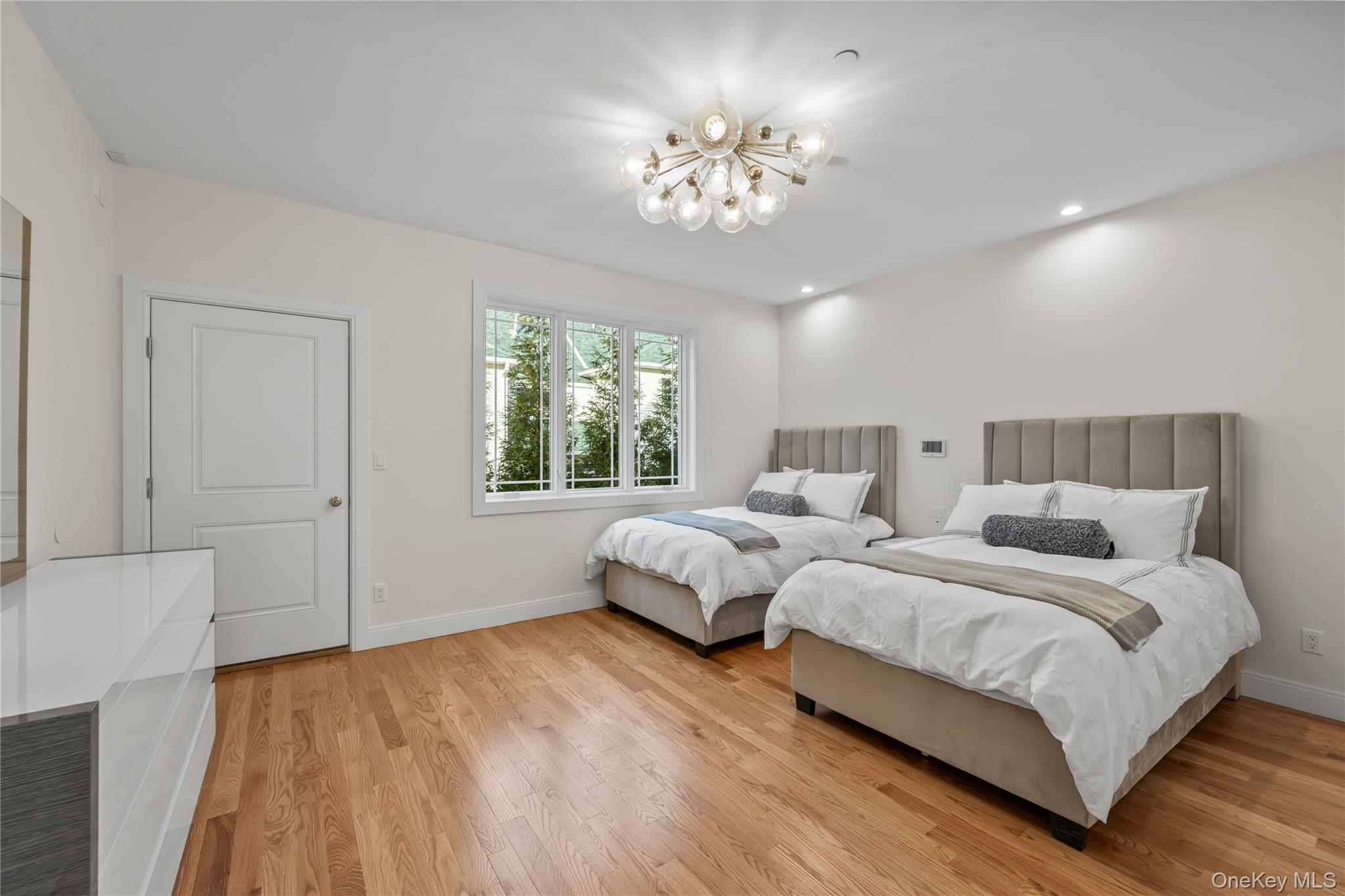 63 Dessau Circle, Unit 52 Spring Valley, NY 10977 - Photo 26 of 48 a spacious bedroom with two beds and a chandelier