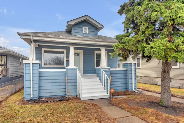 a front view of a house with a tree