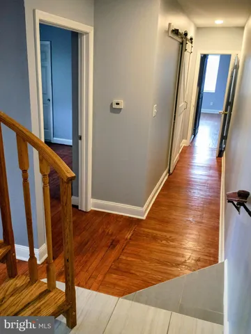 a view of a hallway with wooden floor and staircase
