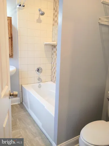 a white bath tub sitting next to a white toilet