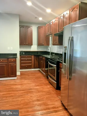a kitchen with stainless steel appliances a refrigerator and a stove top oven