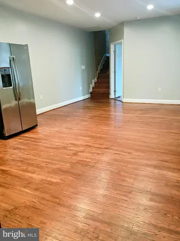 an empty room with wooden floor and mirror