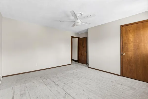 an empty room with a ceiling fan and a window