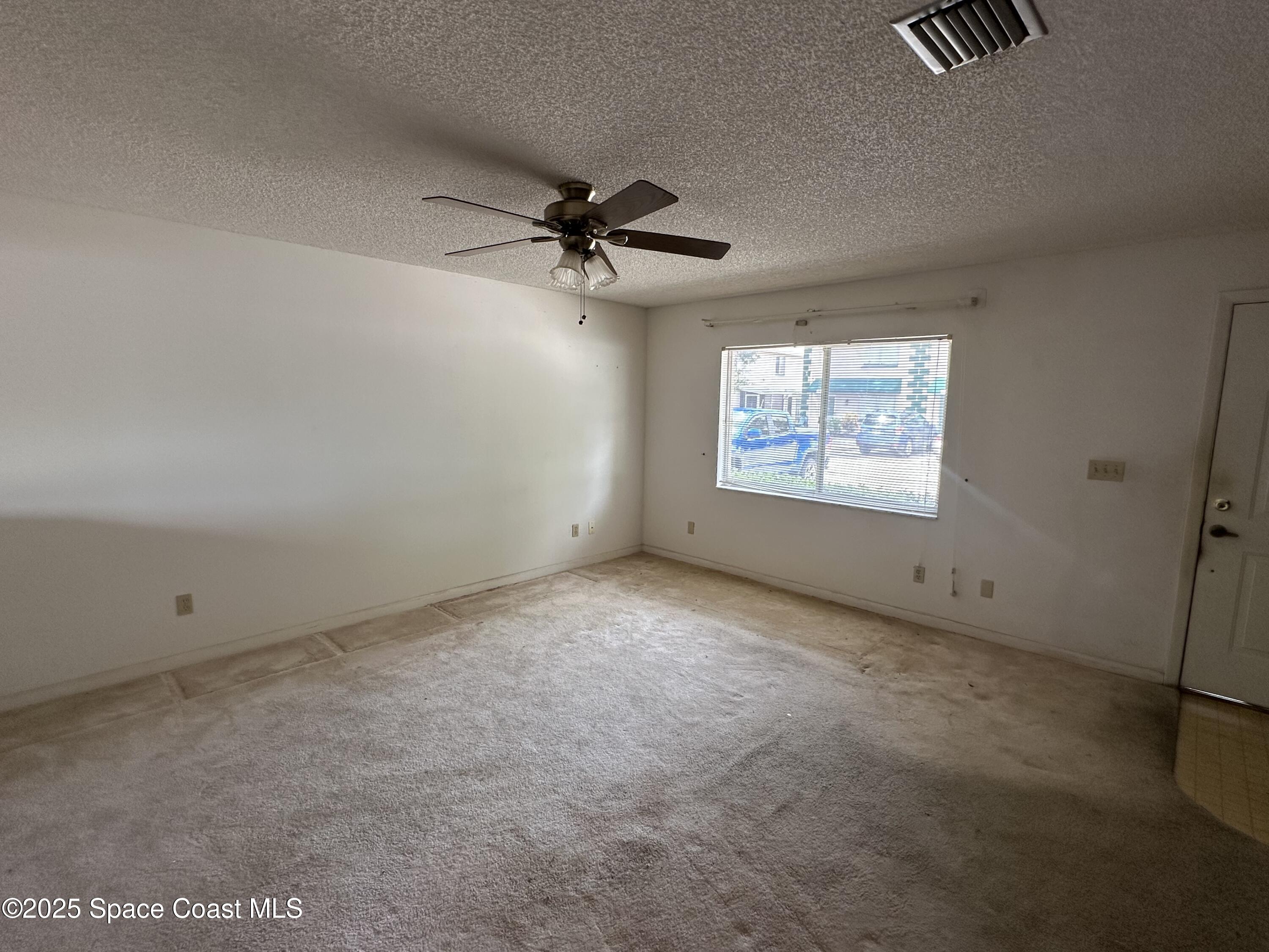 1882 Murrell Road, Unit J36 Rockledge, FL 32955 - Photo 5 of 12 an empty room with windows and fan