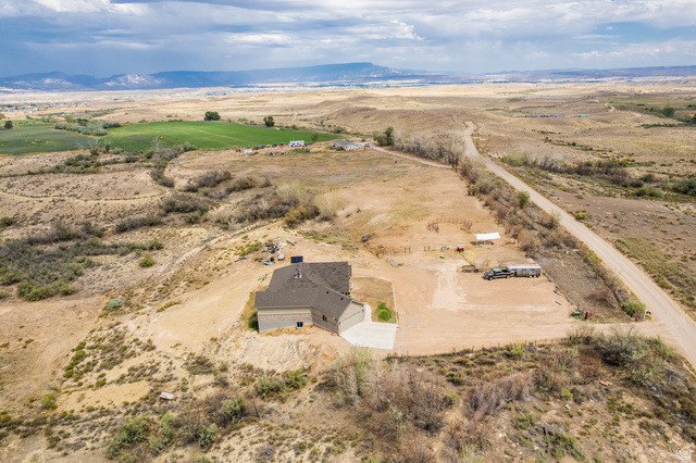 2101 Goose Ranch Road Vernal, UT 84078 - Photo 67 of 72 Expansive rural property featuring a newly constructed residence with a two-car garage, surrounding natural landscape, and distant agricultural fields