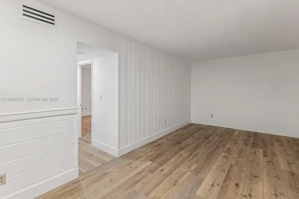 a view of an empty room and wooden floor