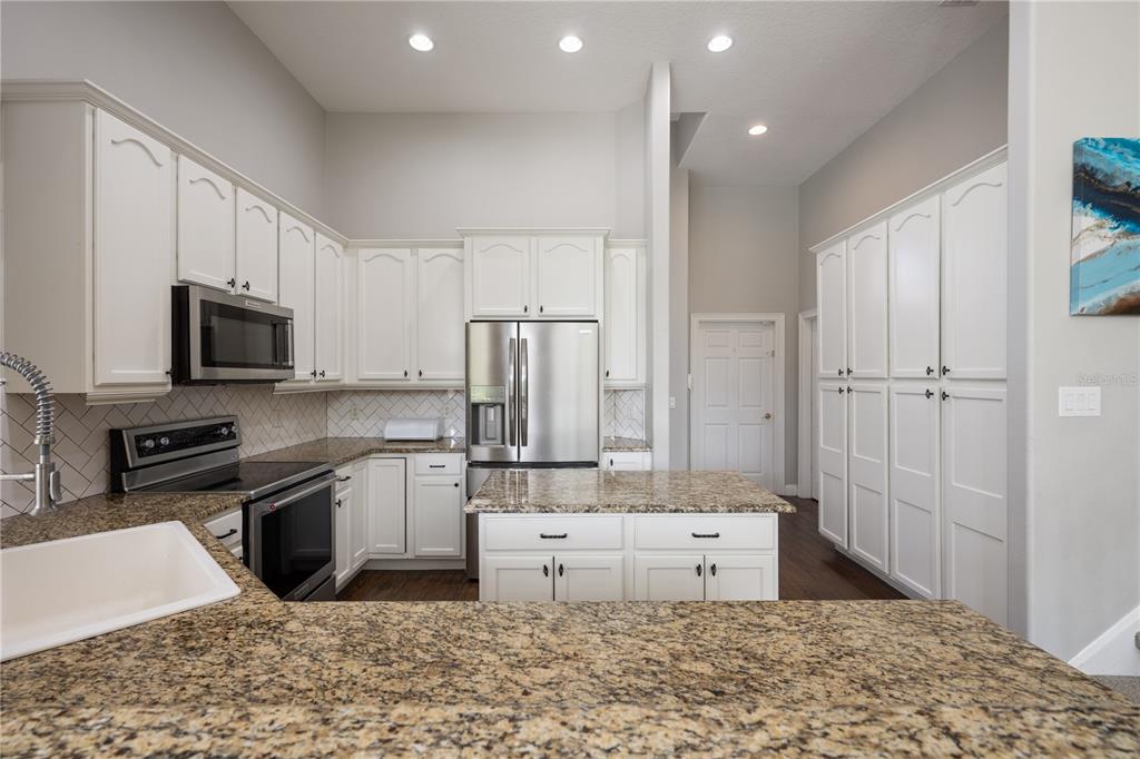 2002 Water Key Drive Windermere, FL 34786 - Photo 14 of 60 a kitchen with stainless steel appliances kitchen island granite countertop a refrigerator oven a sink a stove and white cabinets