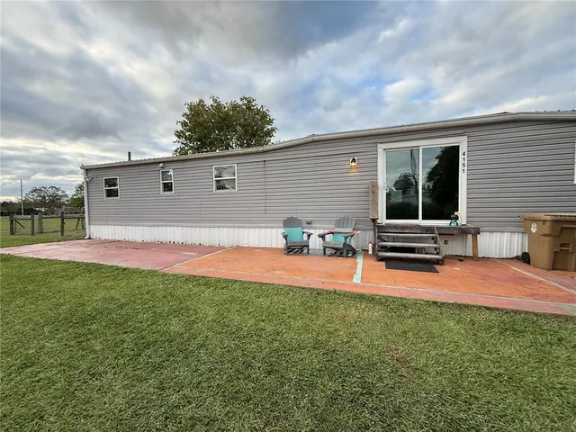 a backyard of a house with table and chairs