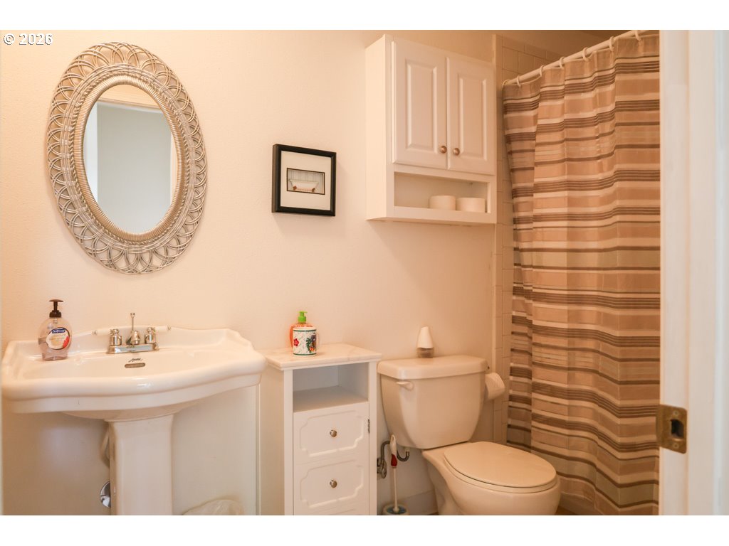 610 Tiara Street Lakeside, OR 97449 - Photo 12 of 28 a bathroom with a toilet a sink and a mirror