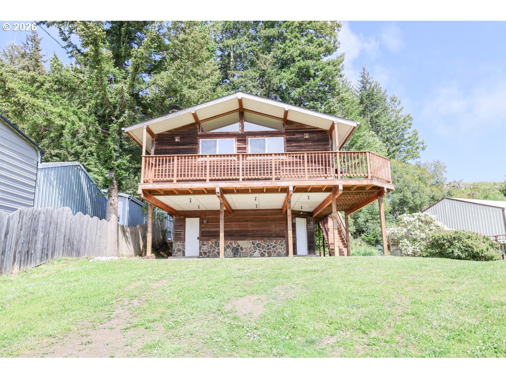 610 Tiara Street Lakeside, OR 97449 - Photo 3 of 28 a view of a house with a yard balcony and wooden fence