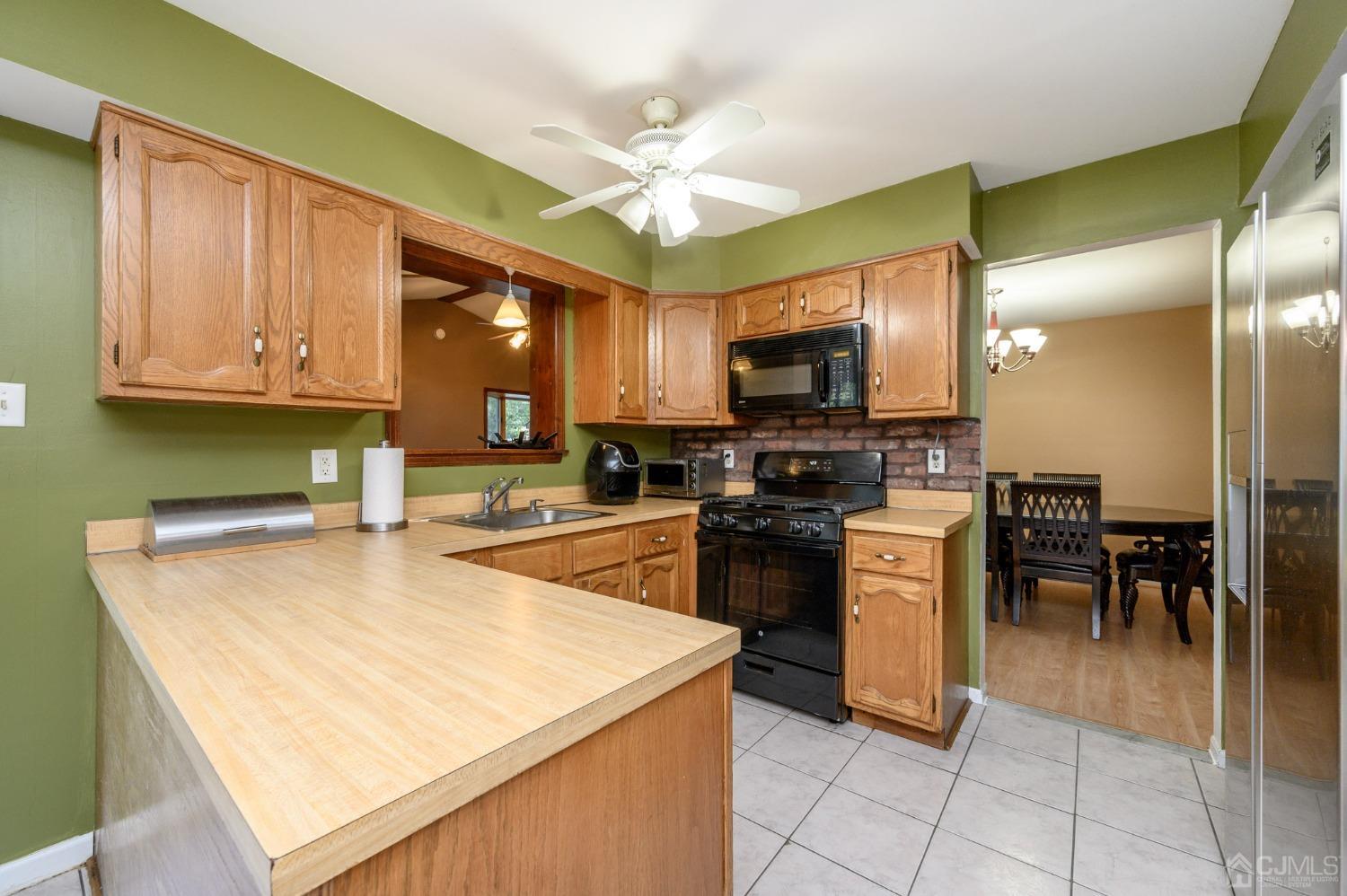 7 Blueberry Path Howell, NJ 07731 - Photo 16 of 39 a kitchen with stainless steel appliances kitchen island granite countertop a stove top oven a sink a counter top space and cabinets