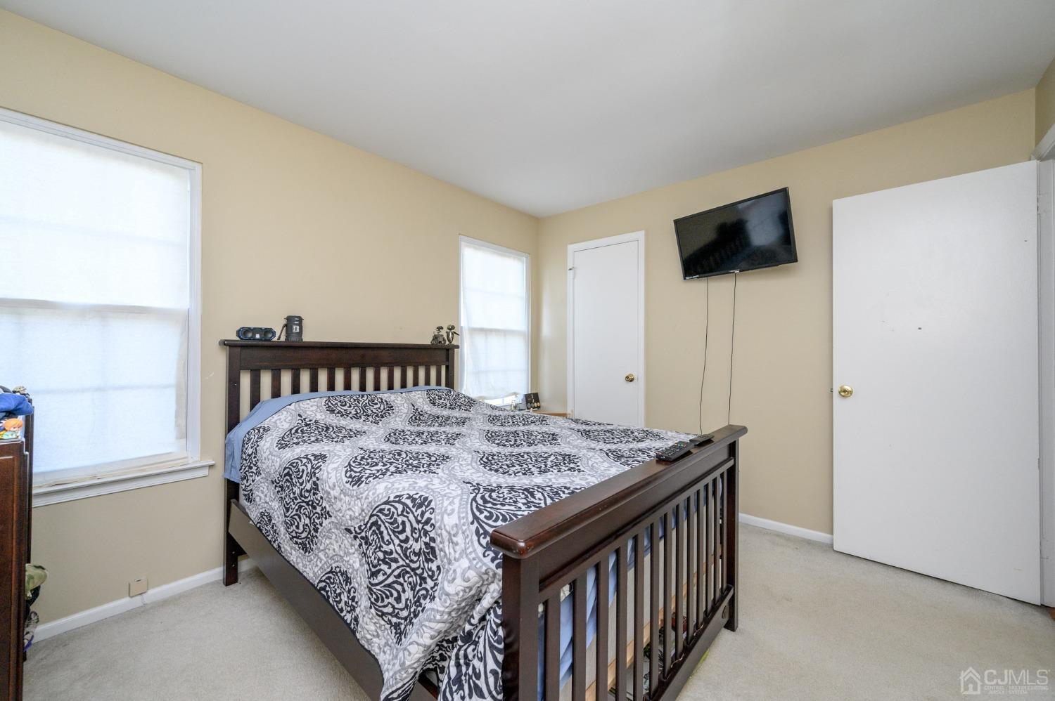 7 Blueberry Path Howell, NJ 07731 - Photo 25 of 39 a bed sitting in a bedroom next to a window with a flat screen tv and a table