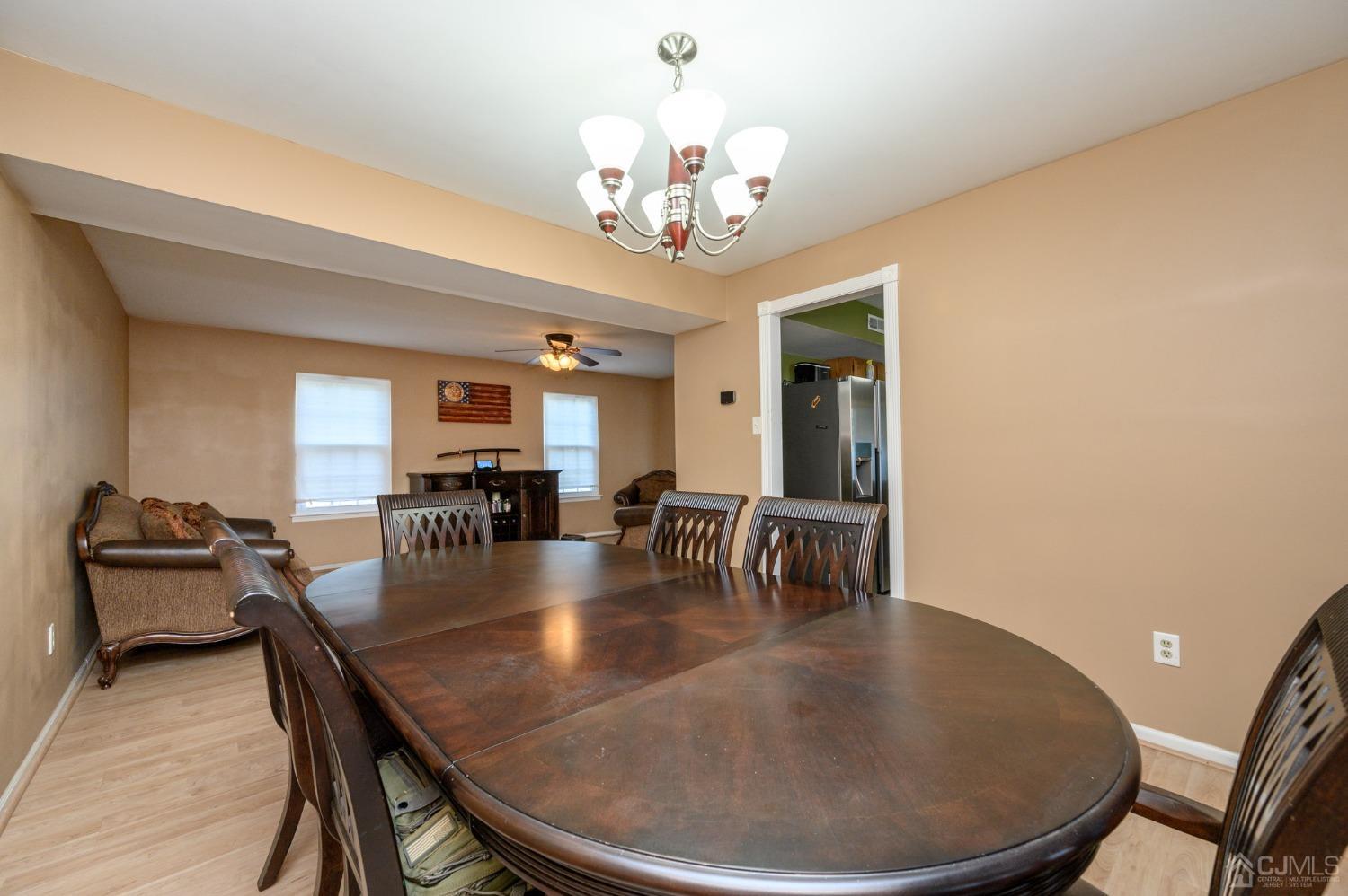 7 Blueberry Path Howell, NJ 07731 - Photo 8 of 39 a dining room with wooden floor a chandelier a wooden table and chairs
