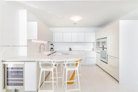 a kitchen with kitchen island a stove a sink and a refrigerator