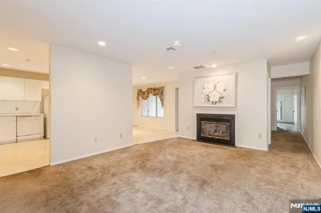an empty room with windows and fireplace