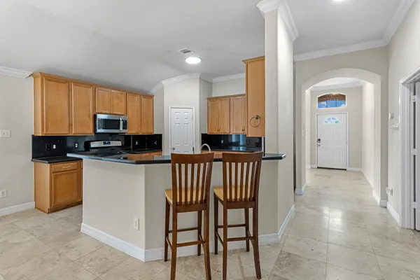 a kitchen with stainless steel appliances granite countertop a stove a sink a microwave a refrigerator and cabinets
