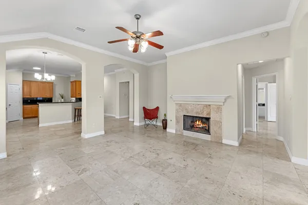 a view of a livingroom with a fireplace a chandelier and windows