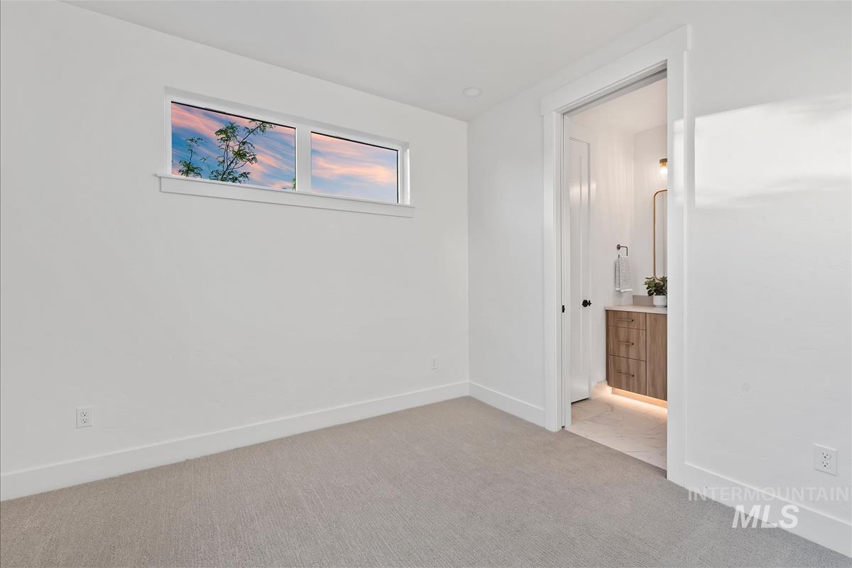3219 West Moore Street Boise, ID 83702 - Photo 31 of 36 Carpeted room featuring a high transom window, crisp white walls, and a recessed doorway