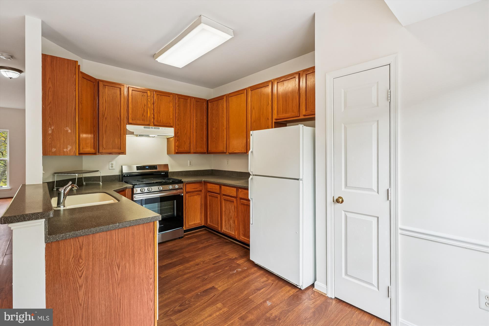3281 Gina Place Woodbridge, VA 22193 - Photo 6 of 27 a kitchen with a refrigerator a stove a sink dishwasher and wooden cabinets with wooden floor