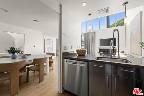 a kitchen with stainless steel appliances a sink cabinets and wooden floor