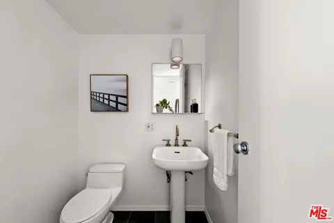 a bathroom with a sink toilet and a mirror