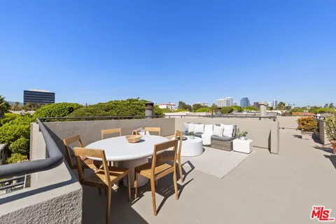 a terrace with outdoor seating and city view