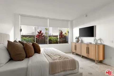 a bedroom with bed and flat screen tv
