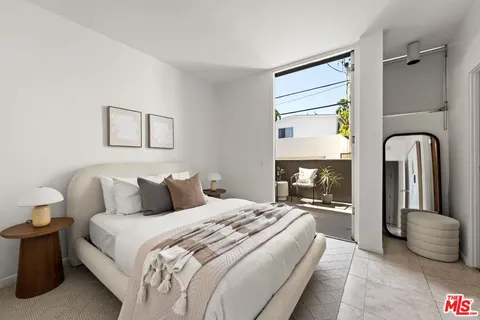 a bedroom with a bed and a large mirror