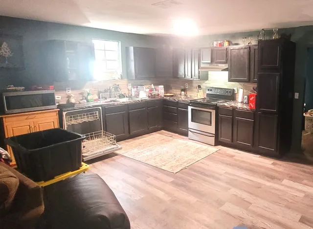 a kitchen with stainless steel appliances granite countertop a sink stove and refrigerator