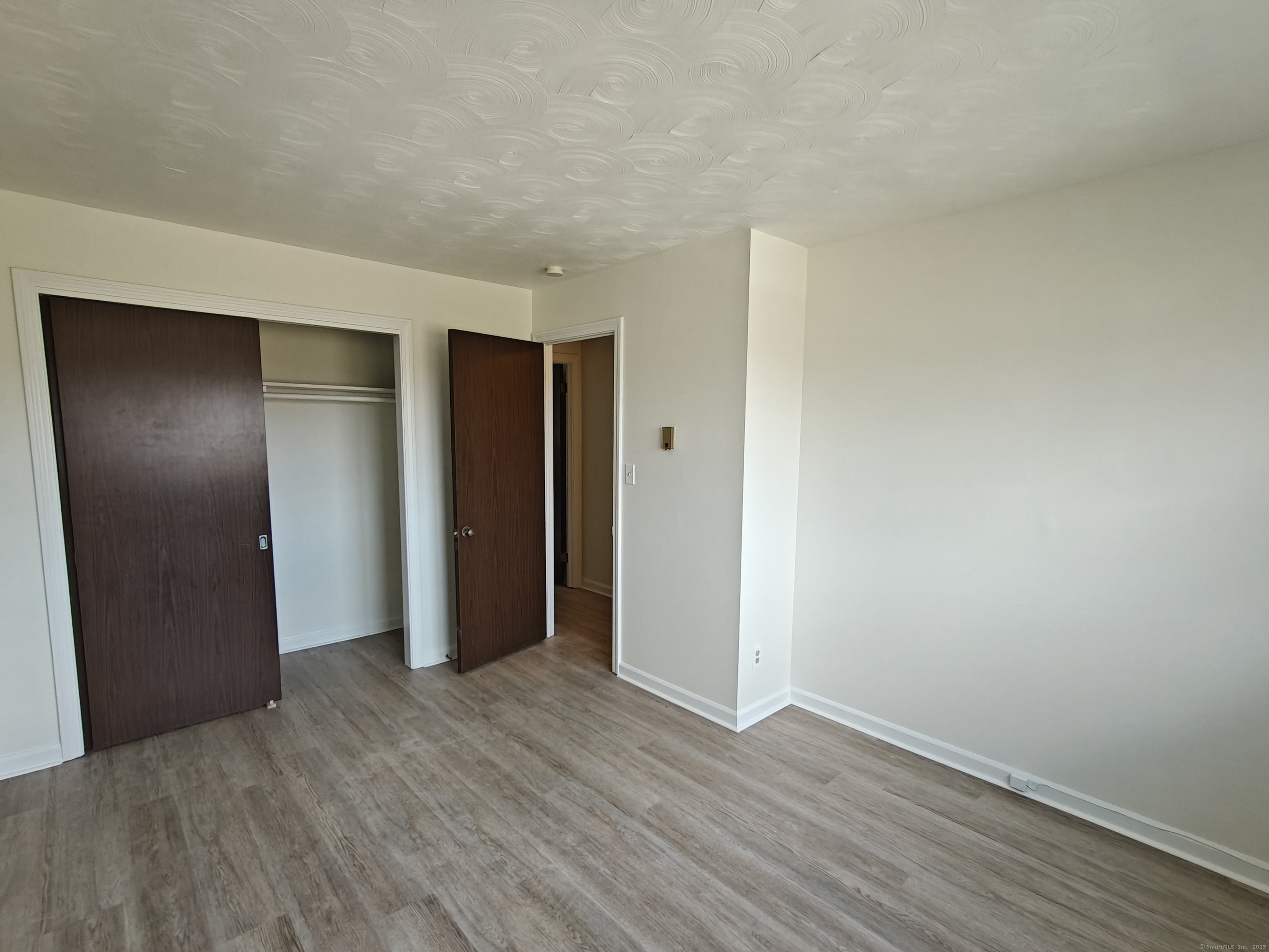 18 Broadview Heights, Unit C Thomaston, CT 06787 - Photo 14 of 15 a view of an empty room with wooden floor and closet