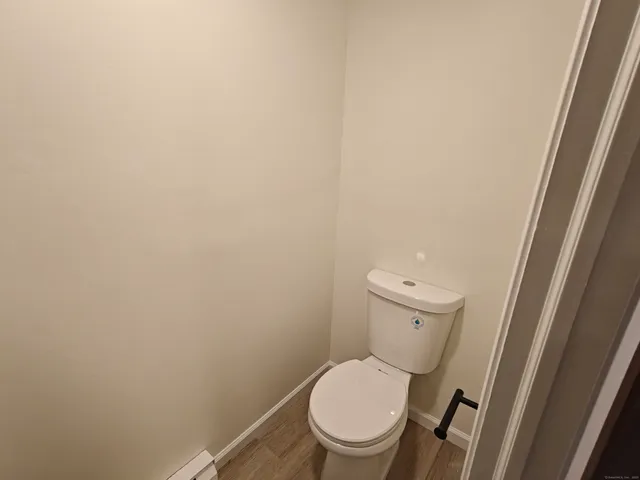 a white toilet sitting next to a shower