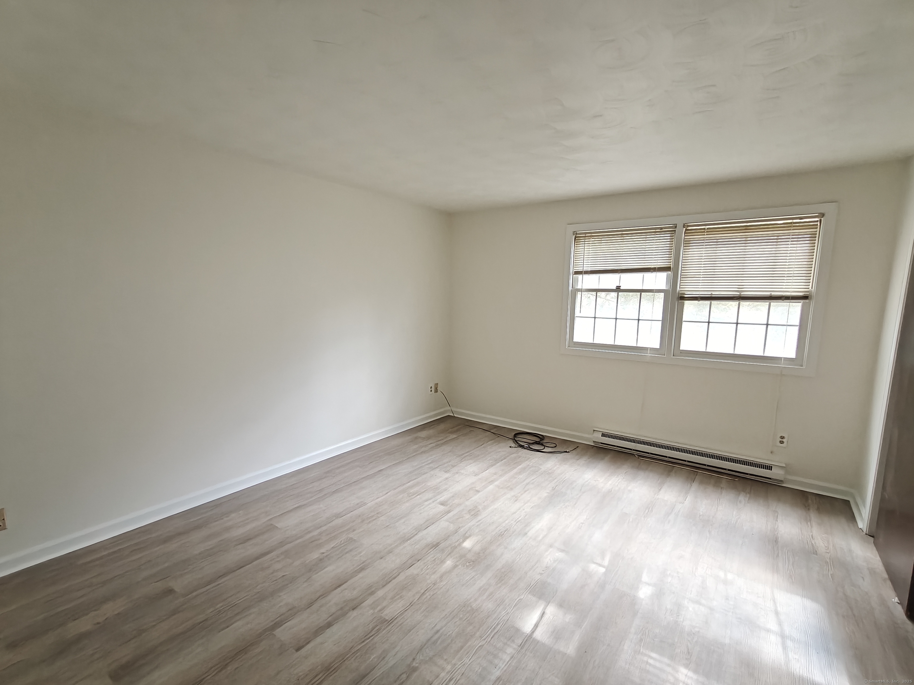 18 Broadview Heights, Unit C Thomaston, CT 06787 - Photo 10 of 15 an empty room with wooden floor and windows