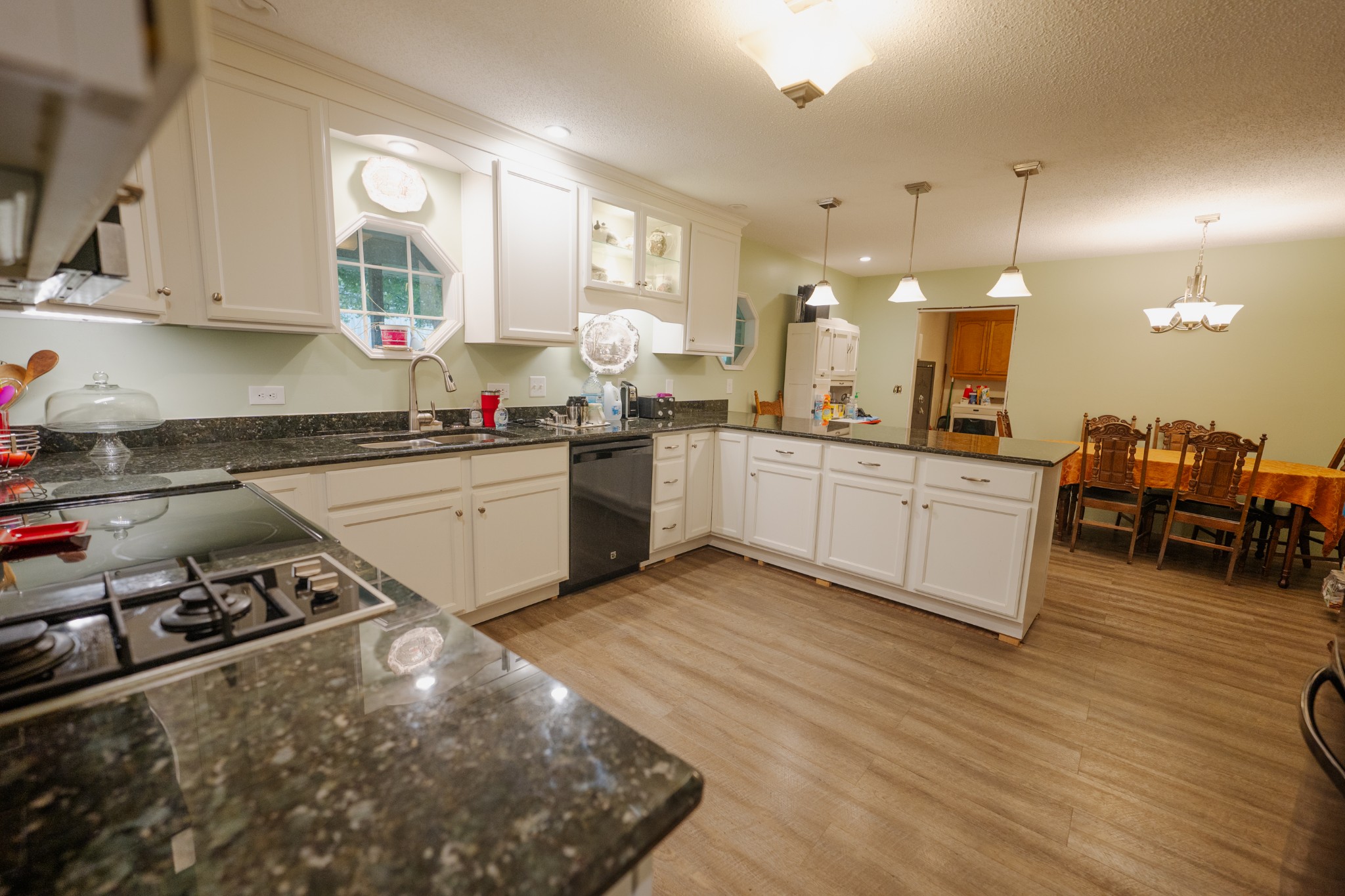 757 Bryson Road Ardmore, TN 38449 - Photo 10 of 40 a kitchen with stainless steel appliances granite countertop a sink dishwasher stove and white cabinets with wooden floor
