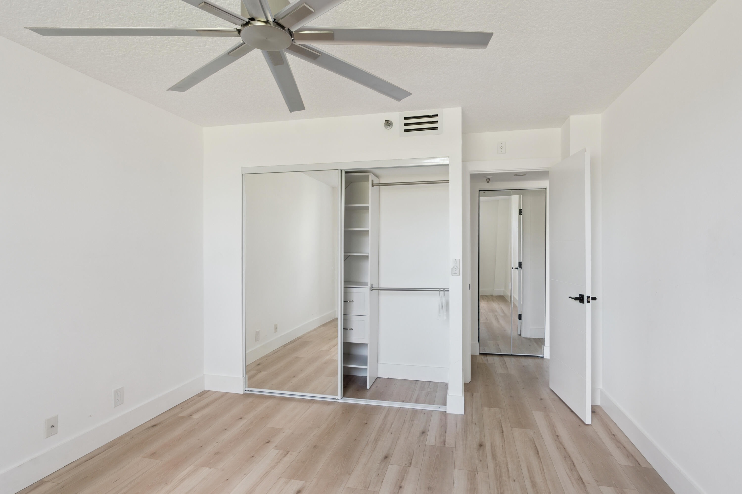 5260 Northwest 2nd Avenue, Unit 105 Boca Raton, FL 33487 - Photo 11 of 24 a view of empty room with wooden floor and ceiling fan