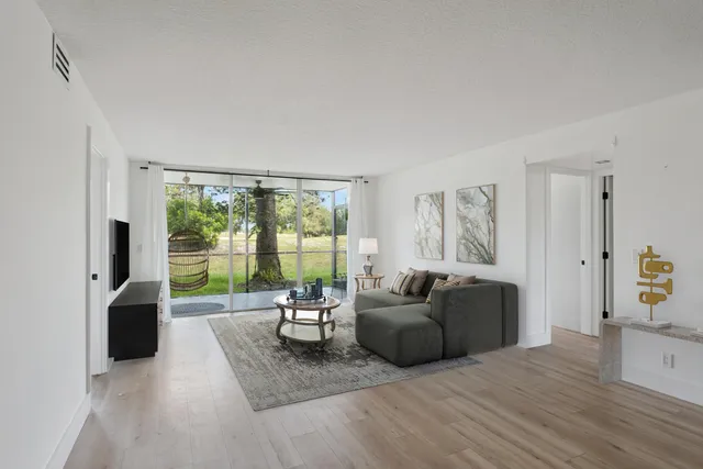 a living room with furniture and large windows